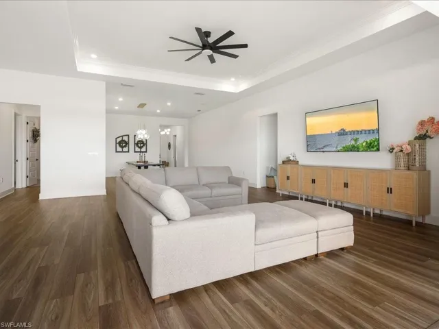 Living area featuring recessed lighting, a ceiling fan, crown molding, and a raised ceiling
