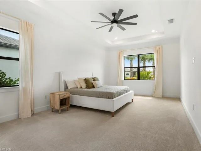 Bedroom featuring visible vents, recessed lighting, a raised ceiling, and light colored carpet