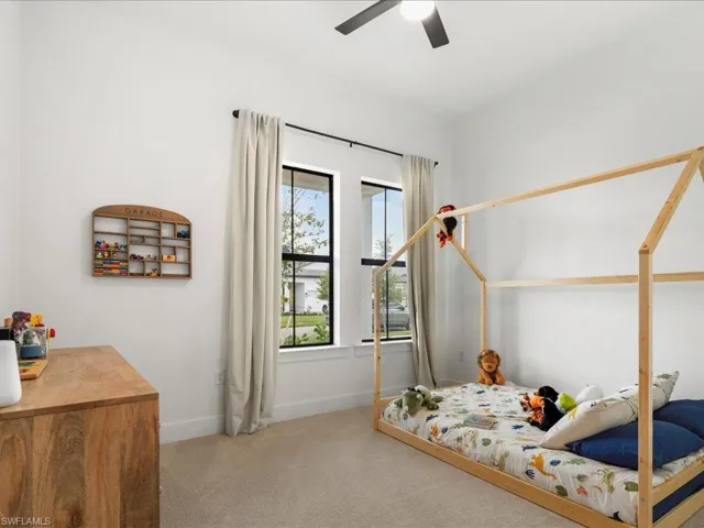 Bedroom featuring baseboards, carpet, and ceiling fan