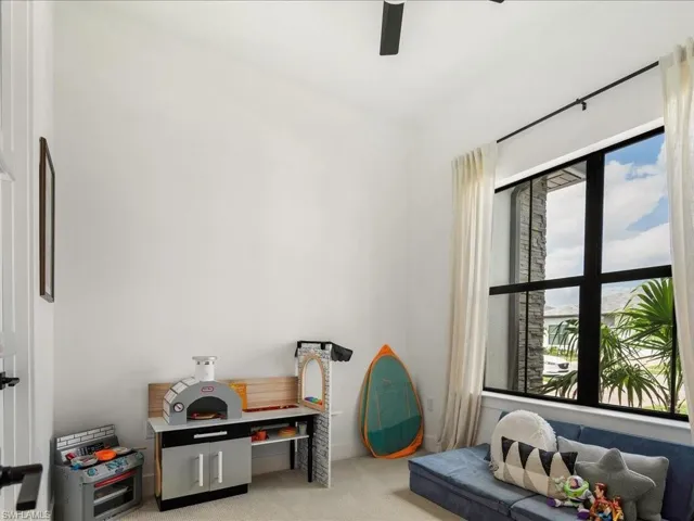 Sitting room with ceiling fan and light carpet