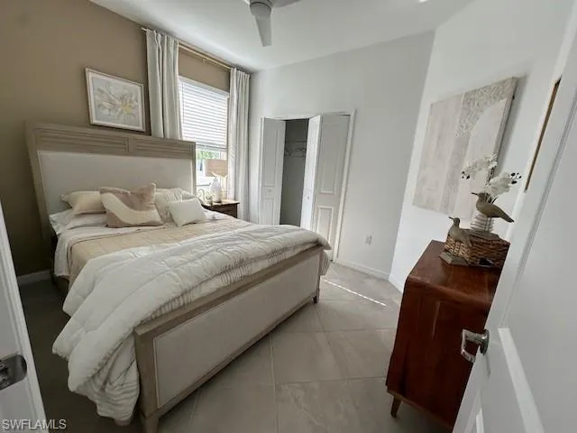 Bedroom featuring tile patterned flooring, a ceiling fan, and a closet