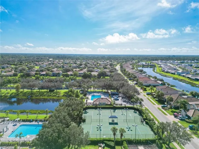Aerial view of residential area with a pool area and a large body of water