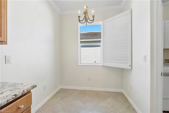 Kitchen Breakfast dining area featuring baseboards, a chandelier, and ornamental molding