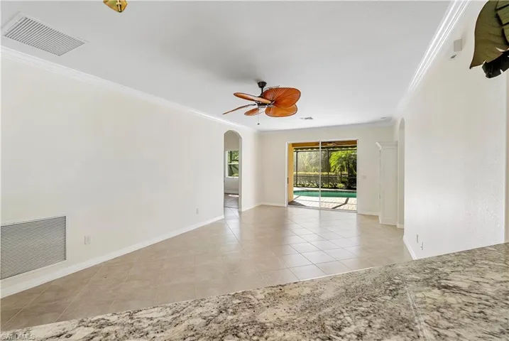 Living Area featuring tile patterned flooring, crown molding, visible vents, and ceiling fan