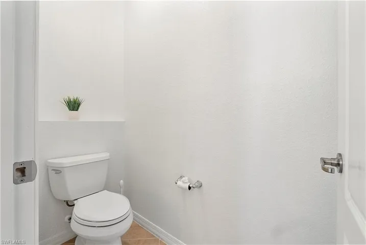 Bathroom featuring tile patterned flooring, toilet, and baseboards