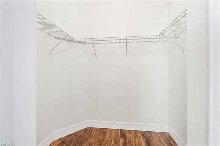 Spacious Master walking closet featuring wood finished floors