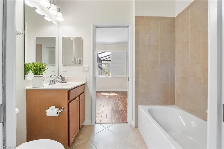 Bathroom featuring baseboards, toilet, vanity, and tile patterned flooring