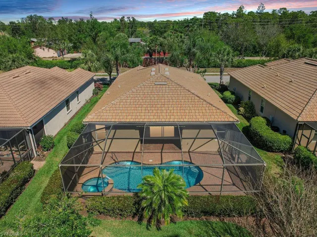 View of swimming pool with glass enclosure, a patio area, and a pool with connected hot tub