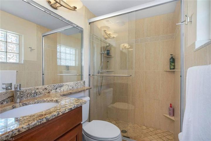 Updated bath with custom cabinet and granite countertops and large walk in tiled shower with Hansgrohe shower head..