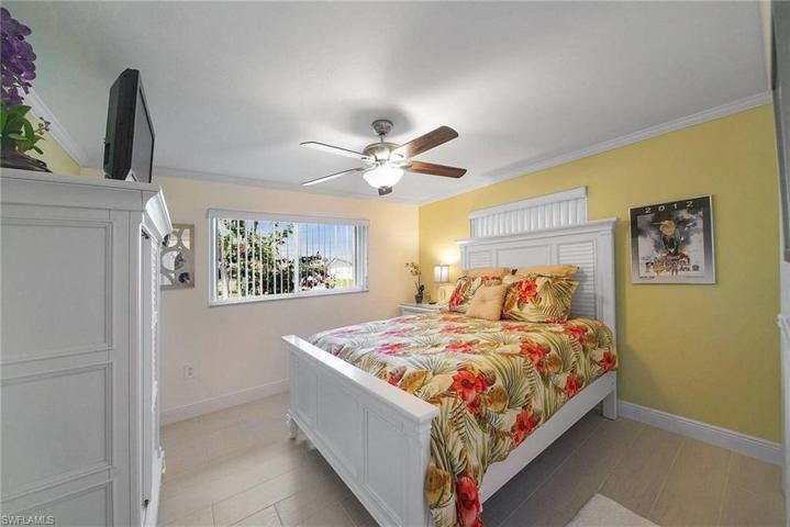 Guest bedroom boasts tile plank floors, crown molding, ceiling fans. A place your guest could definitely feel like their on vacation.