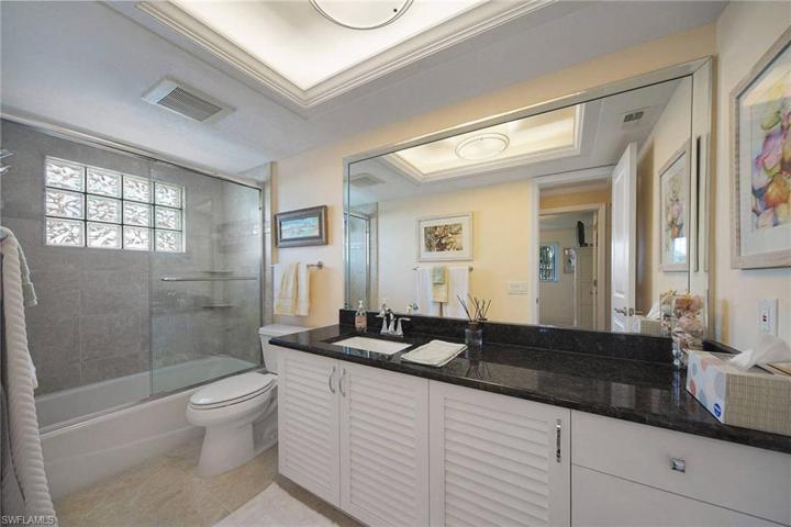 Updated bath with recessed ceilings, custom louvered vanity, granite countertops and tub with glass enclosure updated light fixtures and Hansgrohe shower head..