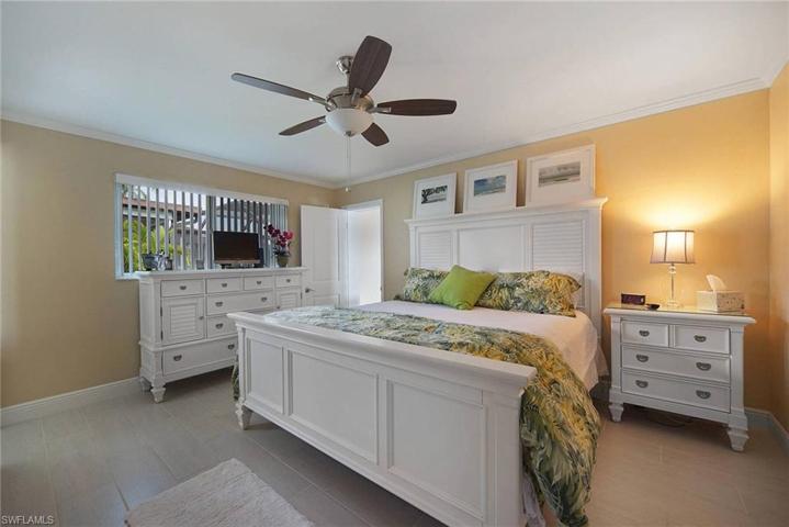 Master bedroom with crown molding, tile plank floors, ceiling fan. Do you feel like your in your own tropical resort yet ? all ceilings fans inside the home are newer.