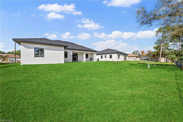 Rear view of house with stucco siding and a patio
