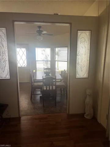 Dining area with a ceiling fan, healthy amount of natural light, and dark wood-style flooring