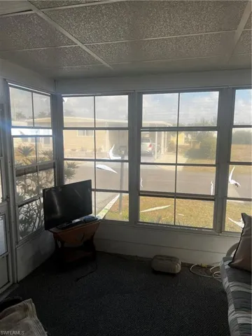Sunroom with carpet and a paneled ceiling