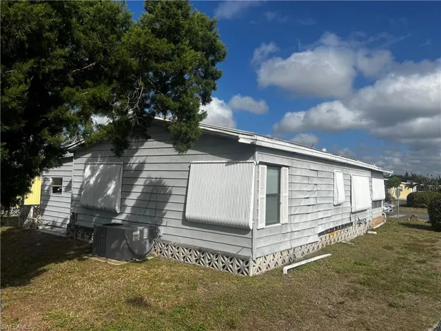 View of property exterior featuring a lawn and crawl space