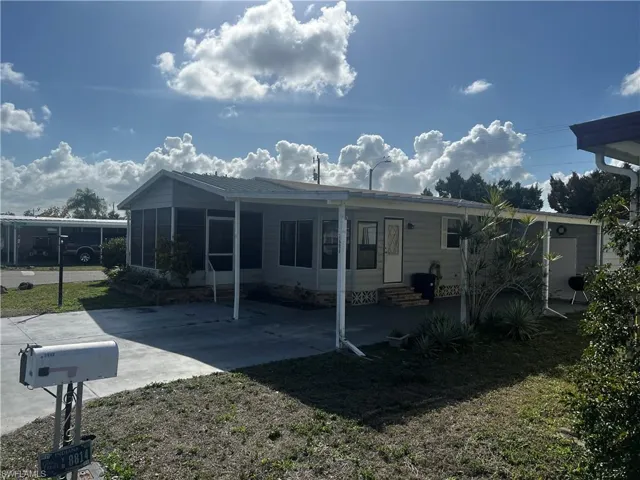 Back of house with a patio, a yard, a carport, and entry steps