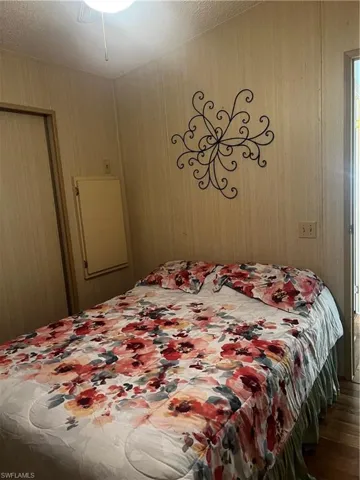 Bedroom with wood finished floors, a textured ceiling, and ceiling fan