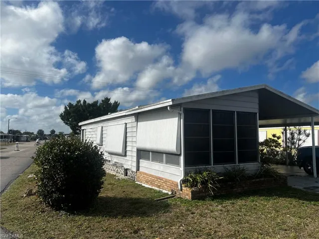 View of side of property featuring a yard and brick siding