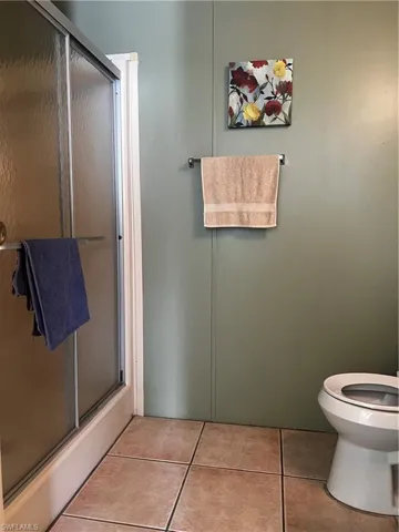 Full bath with a stall shower and light tile patterned floors
