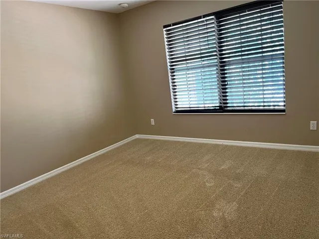Empty room with baseboards and carpet floors