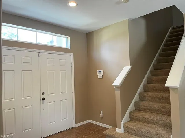 Entrance foyer featuring stairway and dark tile patterned floors