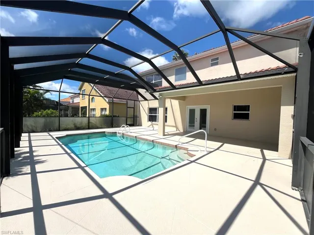 Outdoor pool with french doors, a patio, a sunroom, and glass enclosure