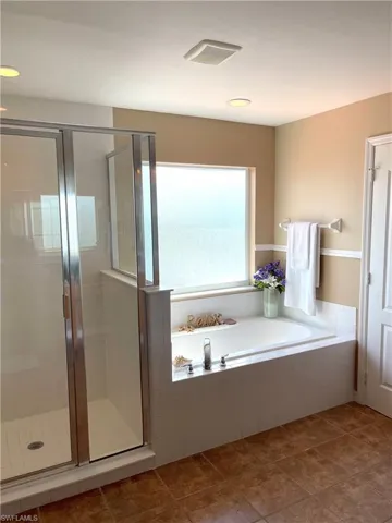 Bathroom with a shower stall, a garden tub, and tile patterned flooring