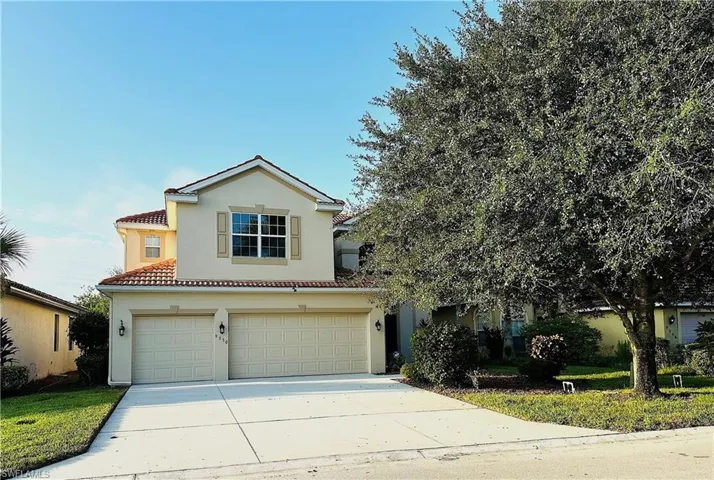 View of front of property featuring an attached garage, concrete driveway, stucco siding, and a tile roof