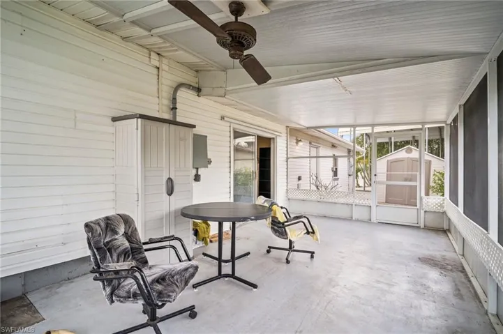 View of patio / terrace featuring an outdoor structure, a ceiling fan, and a storage unit