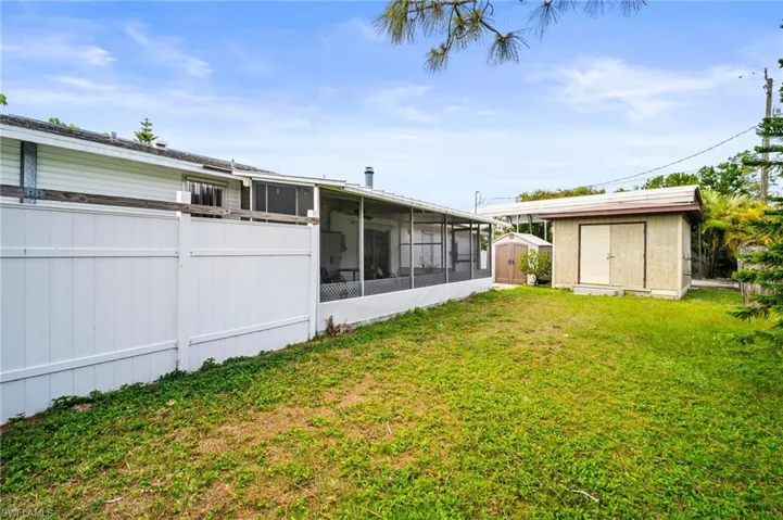 View of yard with a sunroom, a storage unit, and an outdoor structure