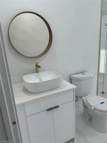 Bathroom with tile flooring, vanity, and toilet