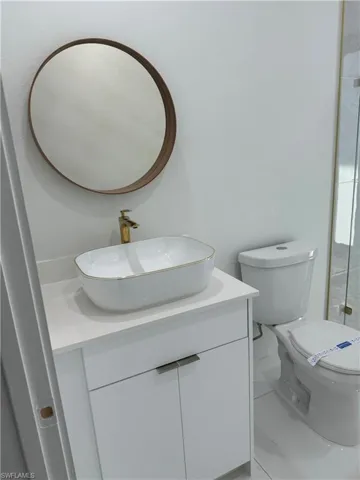 Bathroom featuring tile flooring, vanity, and toilet