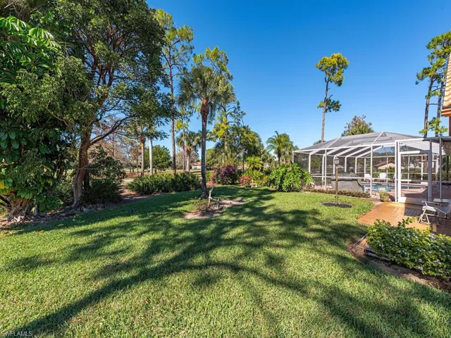 View of green lawn featuring a sunroom and a lanai