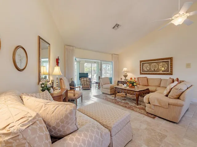 Living room with ceiling fan and high vaulted ceiling