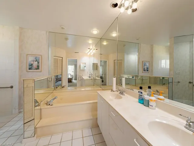 Full bathroom with a garden tub, double vanity, and light tile patterned flooring