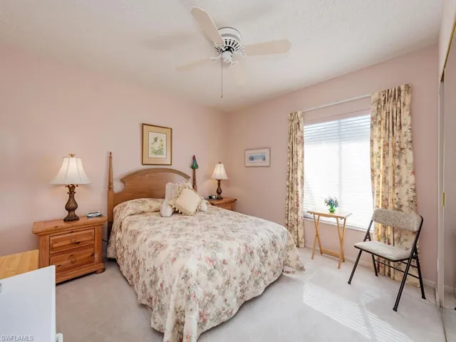 Bedroom with carpet floors, ceiling fan, and a textured ceiling