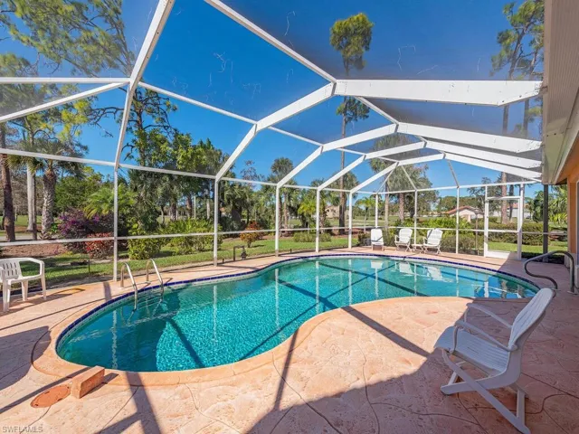 Swimming pool with glass enclosure, a sunroom, and a patio area