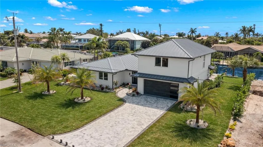 View of front of home with a garage and a front lawn