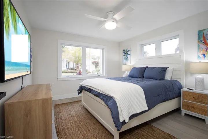 Bedroom featuring multiple windows, dark hardwood / wood-style flooring, and ceiling fan