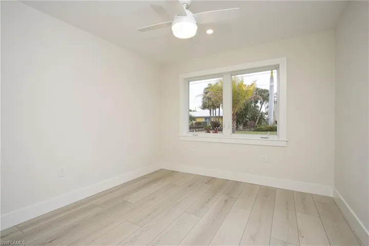 Empty room with ceiling fan and light hardwood / wood-style floors