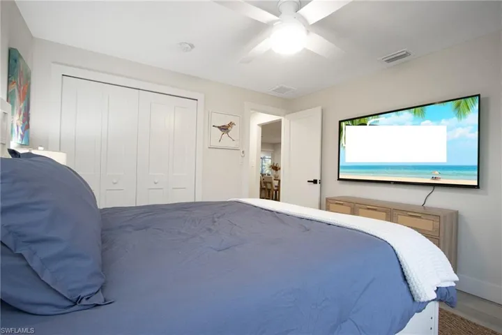 Bedroom with hardwood / wood-style floors, a closet, and ceiling fan