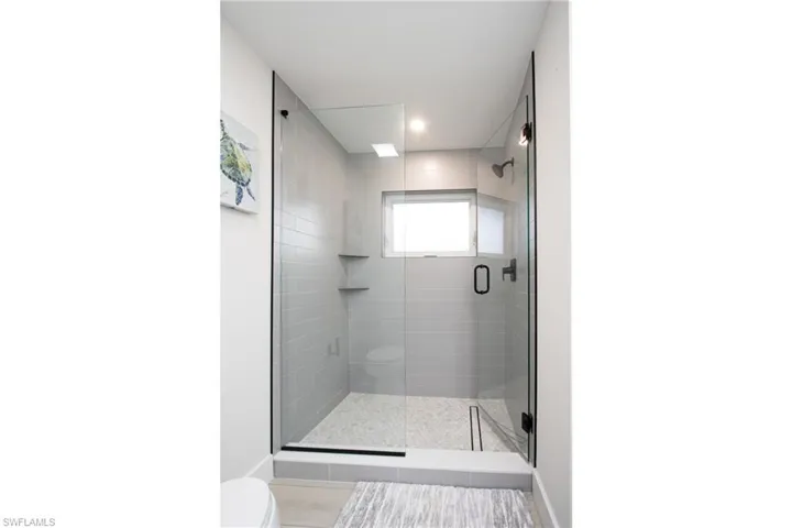 Bathroom with a shower with shower door and toilet