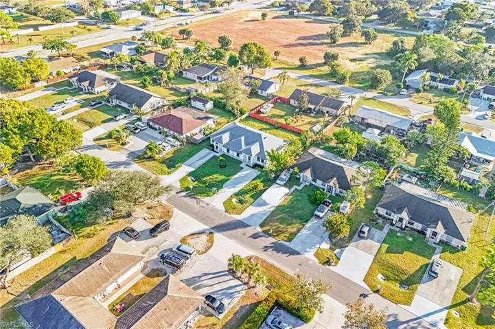 Aerial view of property and surrounding area featuring nearby suburban area