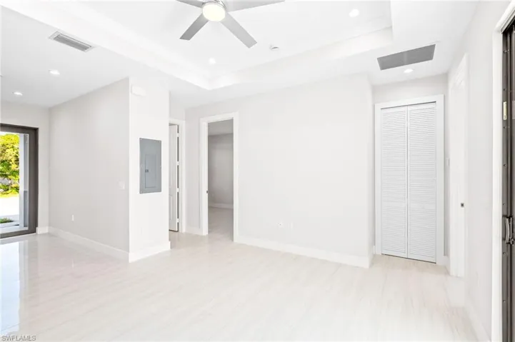 Spare room with recessed lighting, a tray ceiling, electric panel, and ceiling fan