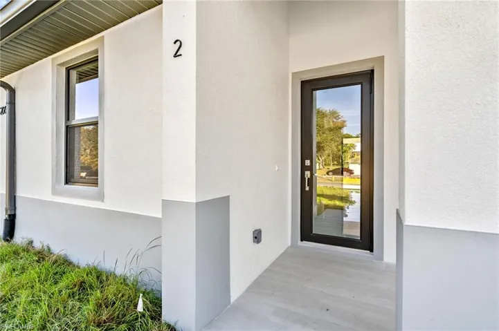 Doorway to property featuring stucco siding
