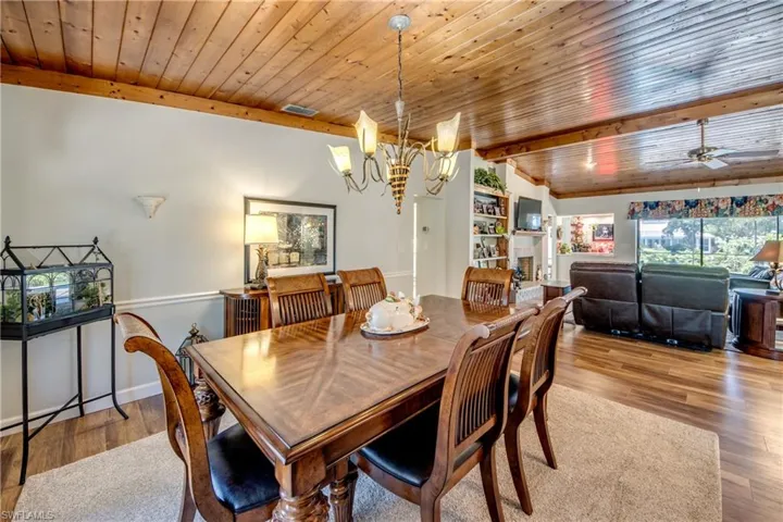 Dining space featuring ceiling fan with notable chandelier, light hardwood / wood-style flooring, and wood ceiling