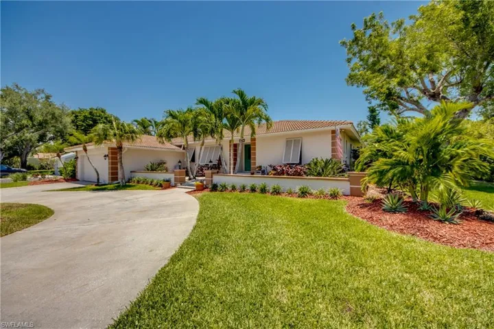 Mediterranean / spanish home with a front yard and a garage