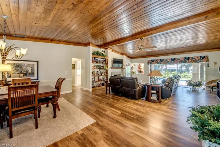 Dining area with wood ceiling, wood-type flooring, and ceiling fan with notable chandelier