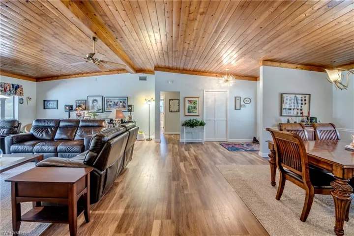 Living room featuring ceiling fan,  luxury vinyl hardwood style ,wood ceiling, and beam ceiling